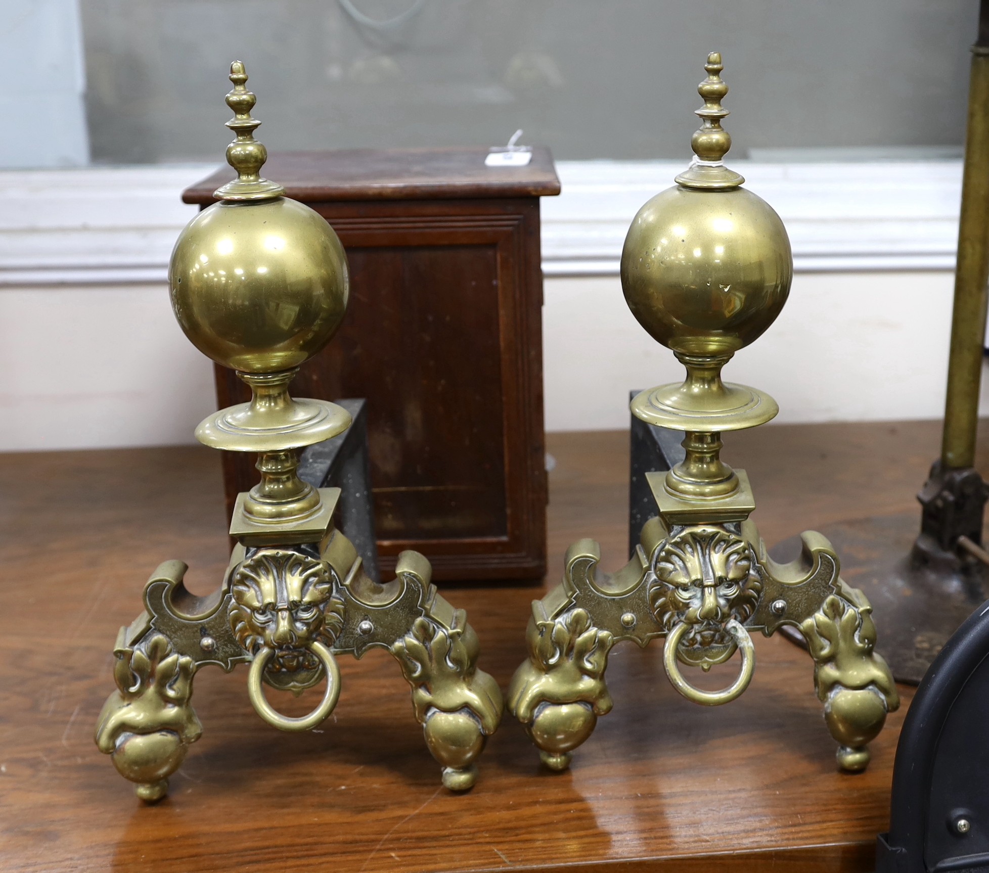 A pair of brass fire dogs